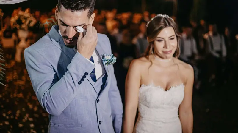 The groom wiping away a tear during the ceremony