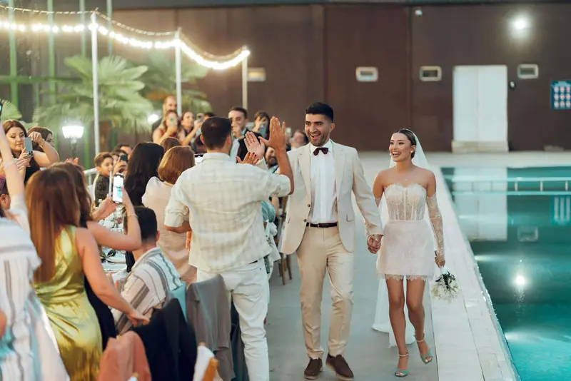 Guests celebrating the couple at a poolside reception